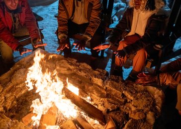 People sitting near the campfire outdoors